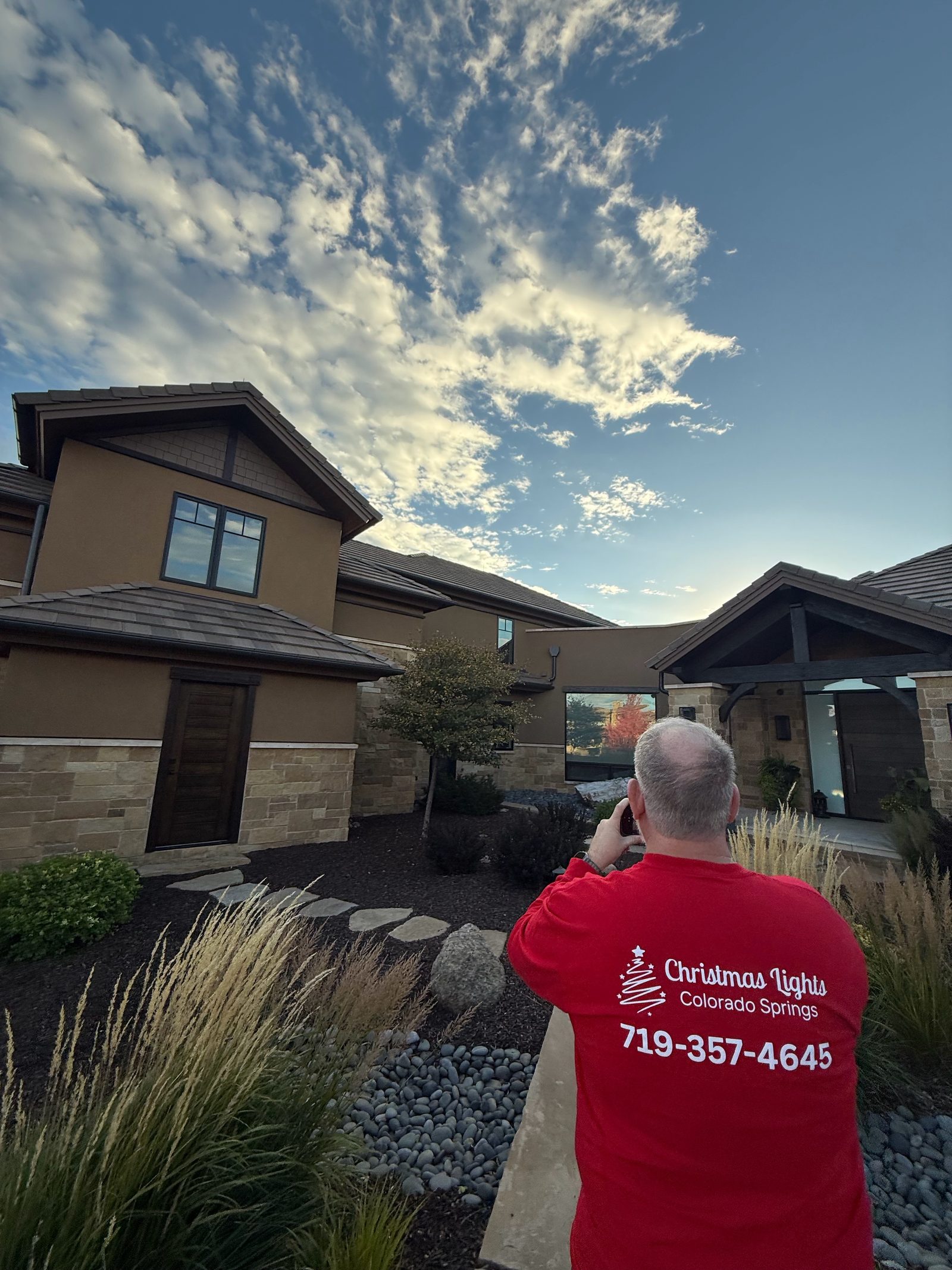 Our technician in branded shirt photographing a finished holiday lighting install