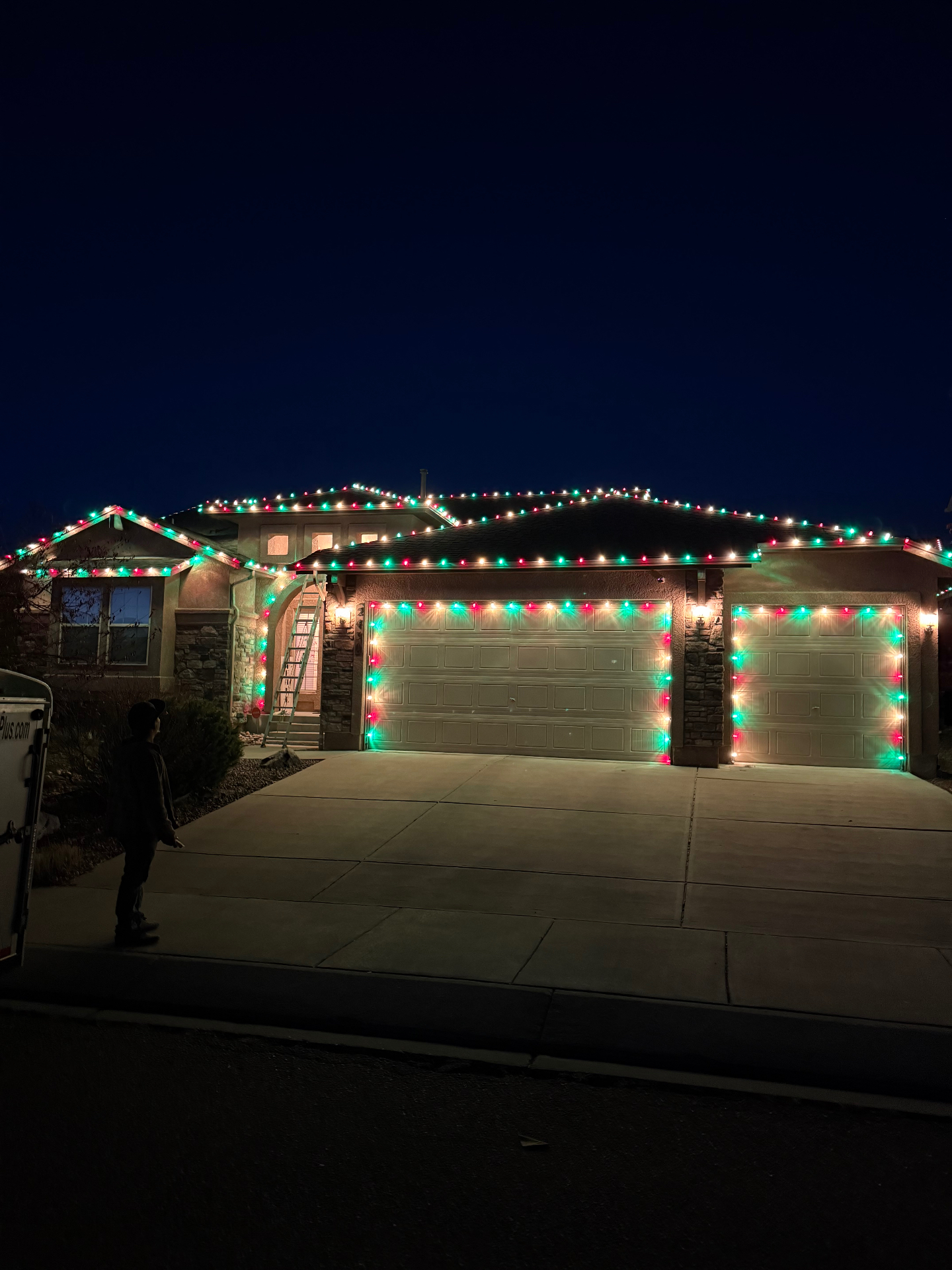 Classic red and green Red and green residential Christmas light installation across a home's roofline and garage on the Front Range
