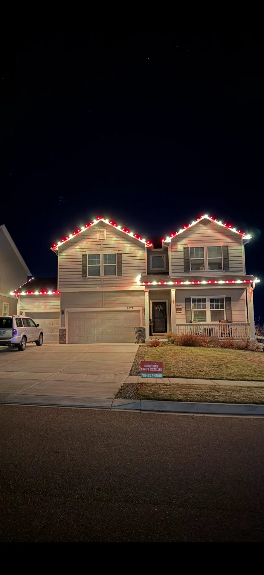Front Range portfolio: red and white LED roofline and garage lighting on a two-story home